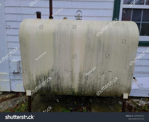 stock-photo-an-oil-tank-on-the-side-of-a-suburban-house-that-is-stained-with-mold-and-mildew-on-it-2237676153